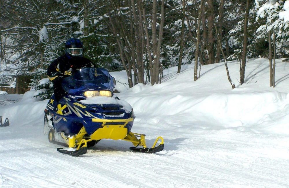 A snowmobiler snowmobiling on a trail