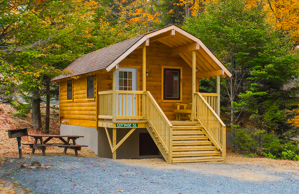 One of the cottages that guests can rent. This rental has a picnic table and a wooden bench in the front.