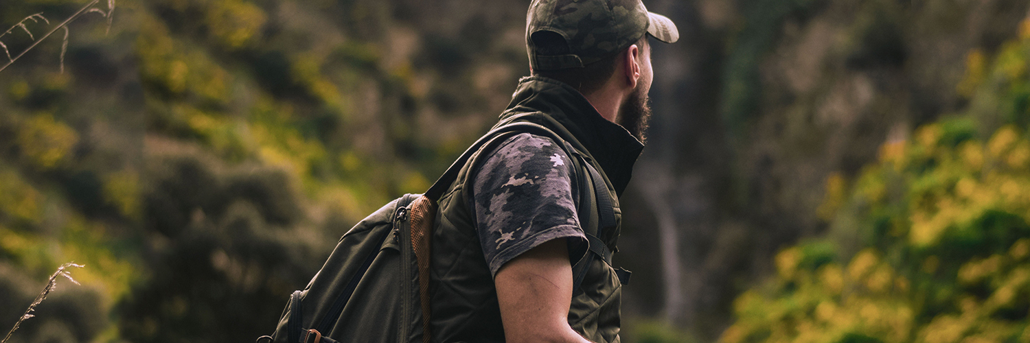 A guy looking around as he walks one of the trails.