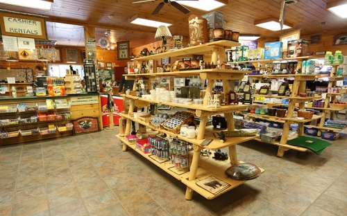 The inside of a small Adirondack store with wooden shelves stocked with local goods