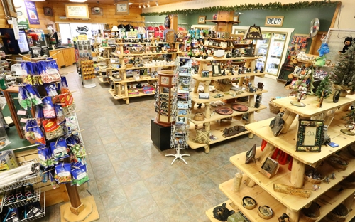 The inside of a small Adirondack store with wooden shelves stocked with local goods