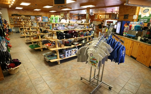 The inside of a small Adirondack store with wooden shelves stocked with local goods