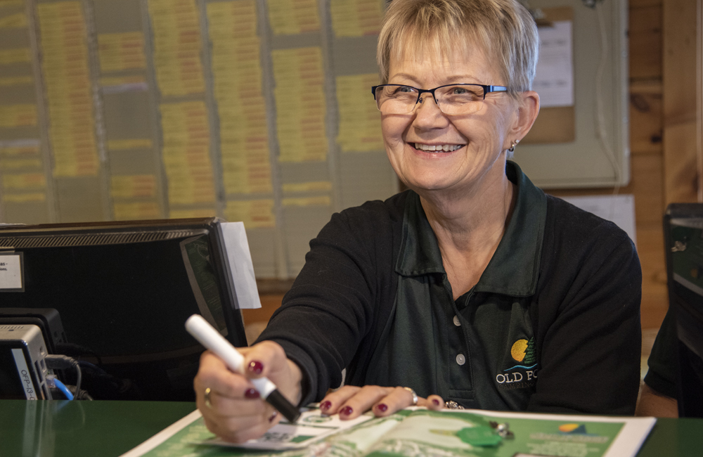 A worker smiling while helping a guest with directions.