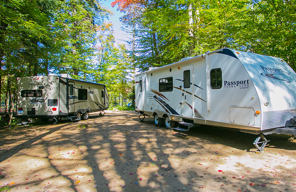 Two RV's and campers parked in the rental sites at Old Forge Camping Resort.