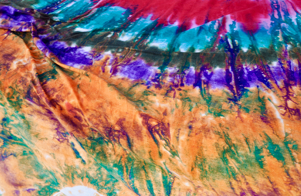 A tie-dyed article. There is purple, orange, blue and green on the tie-dyed piece.