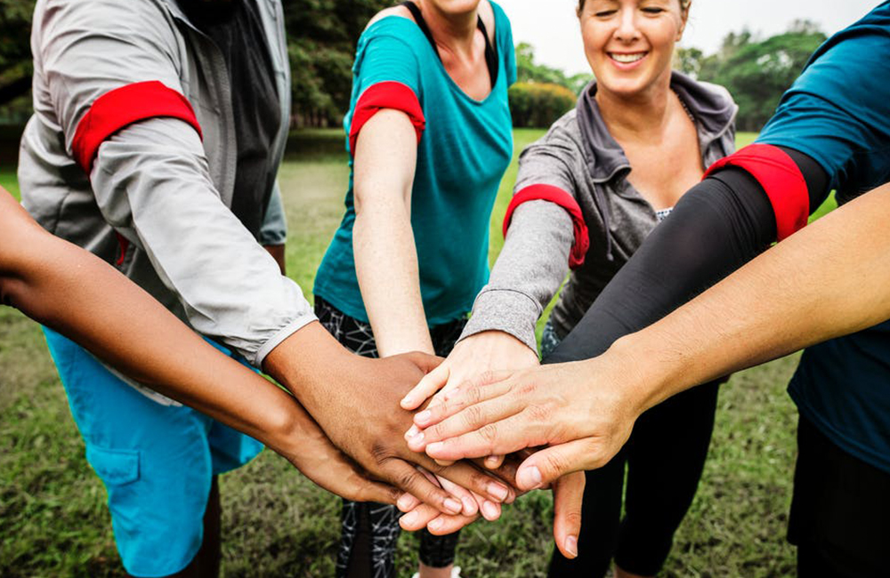 a group of people in a huddle with their hands together